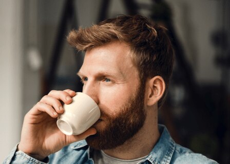 man som dricker en kopp kaffe